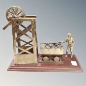 A brass figure of a coal miner and pit shaft on plinth
