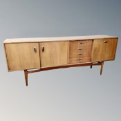 A mid century teak G-plan low sideboard fitted with drawers and cocktail unit