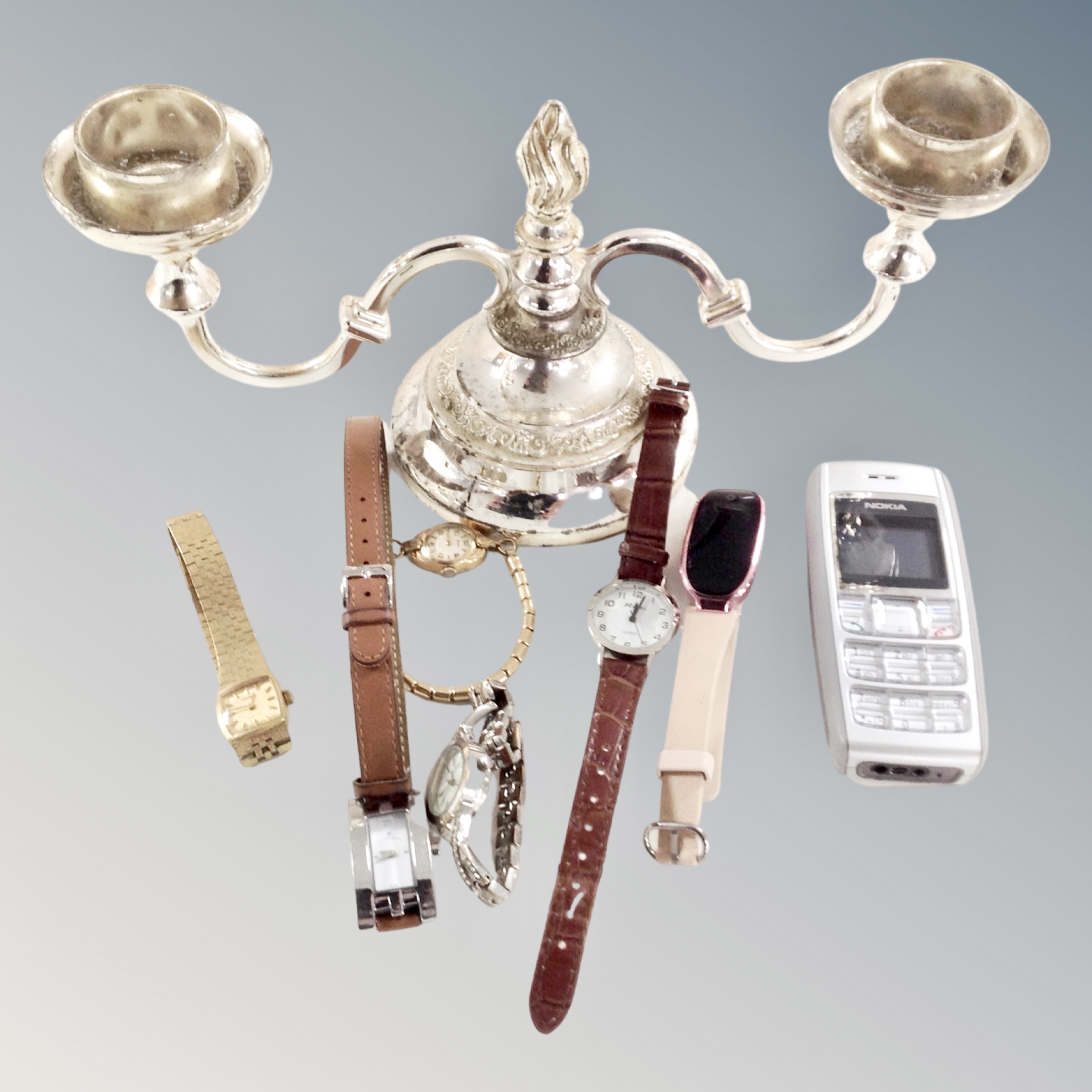 A two-way plated candelabra together with six assorted lady's wristwatches and a Nokia mobile phone.