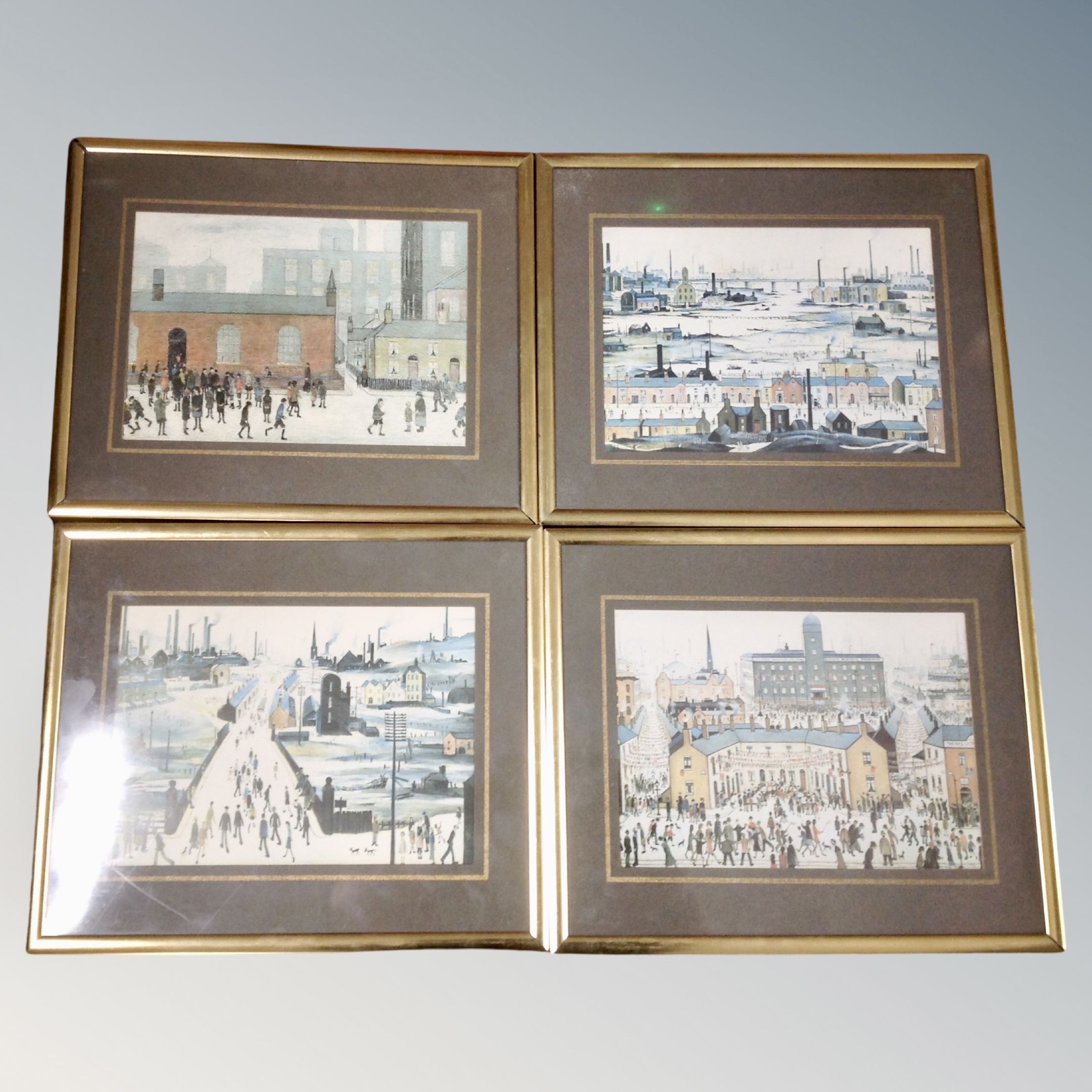 Four L S Lowry prints in brass frames.