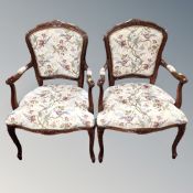 A pair of carved beech open salon armchairs upholstered in a tapestry fabric.