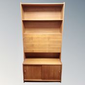 A 20th century Gibbs furniture teak cocktail bookcase, fitted cupboards beneath,