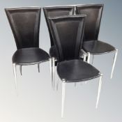 A set of four contemporary black stitched leather dining chairs on metal legs.