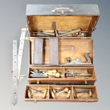 A vintage joiner's toolbox containing hand tools, woodworking plane, sharpeners,
