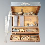 A vintage joiner's toolbox containing hand tools, woodworking plane, sharpeners,