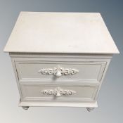 A cream two drawer bedside chest with knob handles together with a painted blanket box.