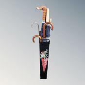 A hand-painted metal stick stand containing umbrellas and walking sticks to include dog's head