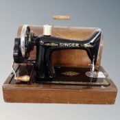 A vintage Singer hand sewing machine in case.