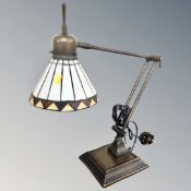 A contemporary angle poise desk lamp with leaded glass shade.