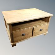 A contemporary pine coffee table fitted shelves and drawers,