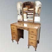 A 1930s oak dressing table with triple mirror.