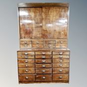 An early 20th century haberdashery cabinet with twenty-six drawers and sliding doors,