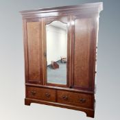 A late Victorian inlaid mahogany mirror door wardrobe, fitted drawers beneath,