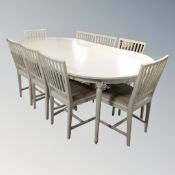 A Danish circular extending dining table with three leaves together with a set eight rail back
