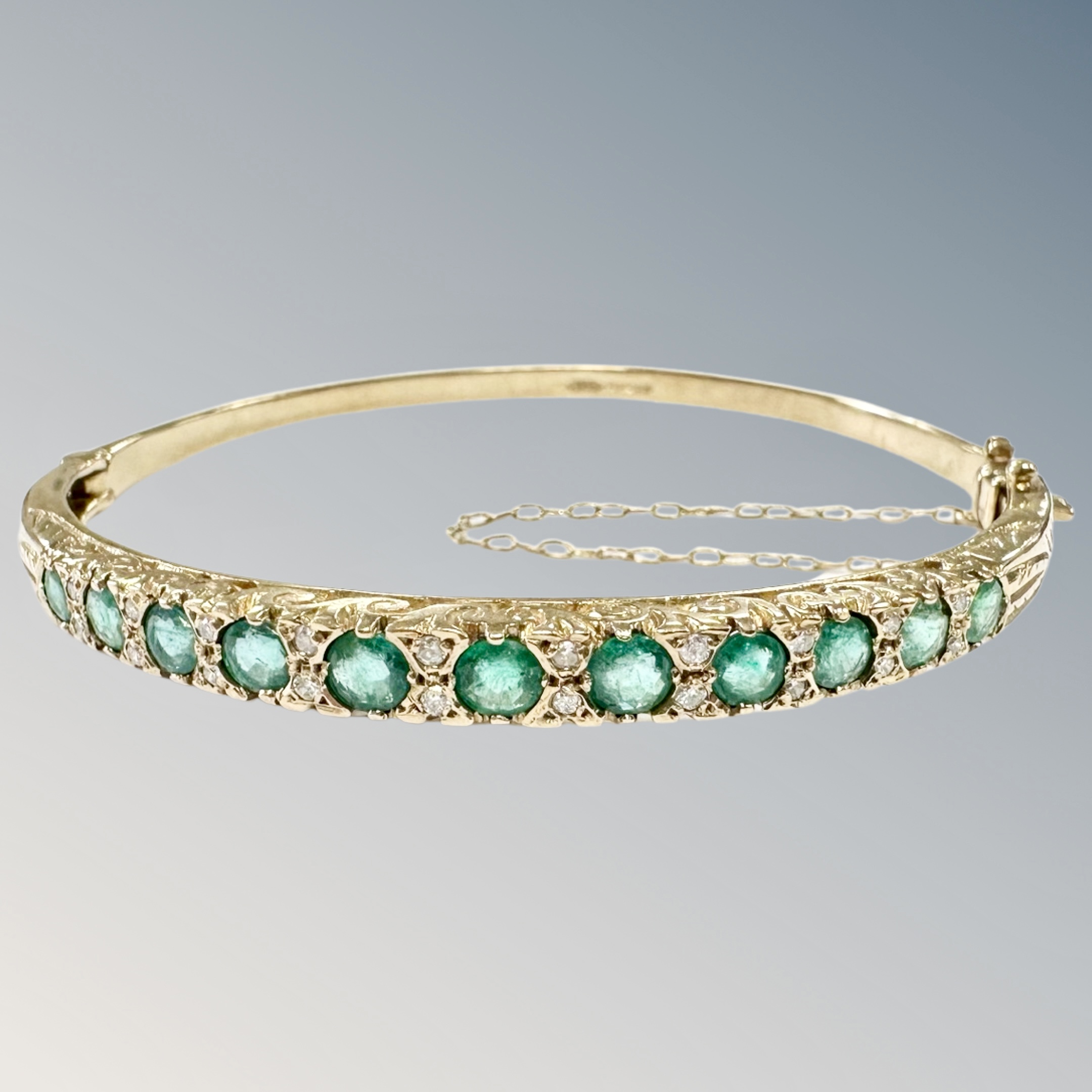 A 9ct gold emerald and diamond bangle,