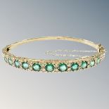 A 9ct gold emerald and diamond bangle,