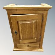 A Danish blonde oak single door wall cabinet, fitted a drawer.