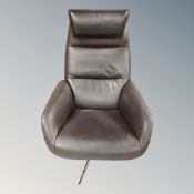 A leather upholstered manual reclining high-back armchair with headrest on a chrome swivel base.