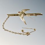 A 9ct gold swallow bar brooch with ruby-set eye, with safety chain, length 41mm.