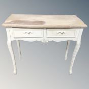 A shabby chic side table fitted two drawers and raised legs,