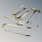 Five pairs of Georgian/William IV sugar tongs and a spoon,