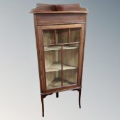 A late Victorian inlaid mahogany glazed door corner cabinet on raised legs.