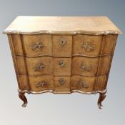 A 19th century oak serpentine front three drawer chest on raised legs,
