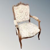 A late 19th century carved open armchair upholstered in tapestry fabric.