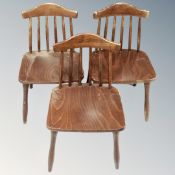 A set of three stained beech spindle back dining chairs.
