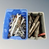 Two plastic crates containing oversized drill bits and ring spanners.