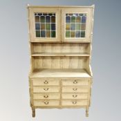 A 20th century Danish blonde oak bookcase with leaded glass drawers fitted eight drawers beneath,