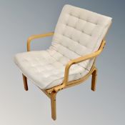 A retro style open bentwood armchair with cream cushion.