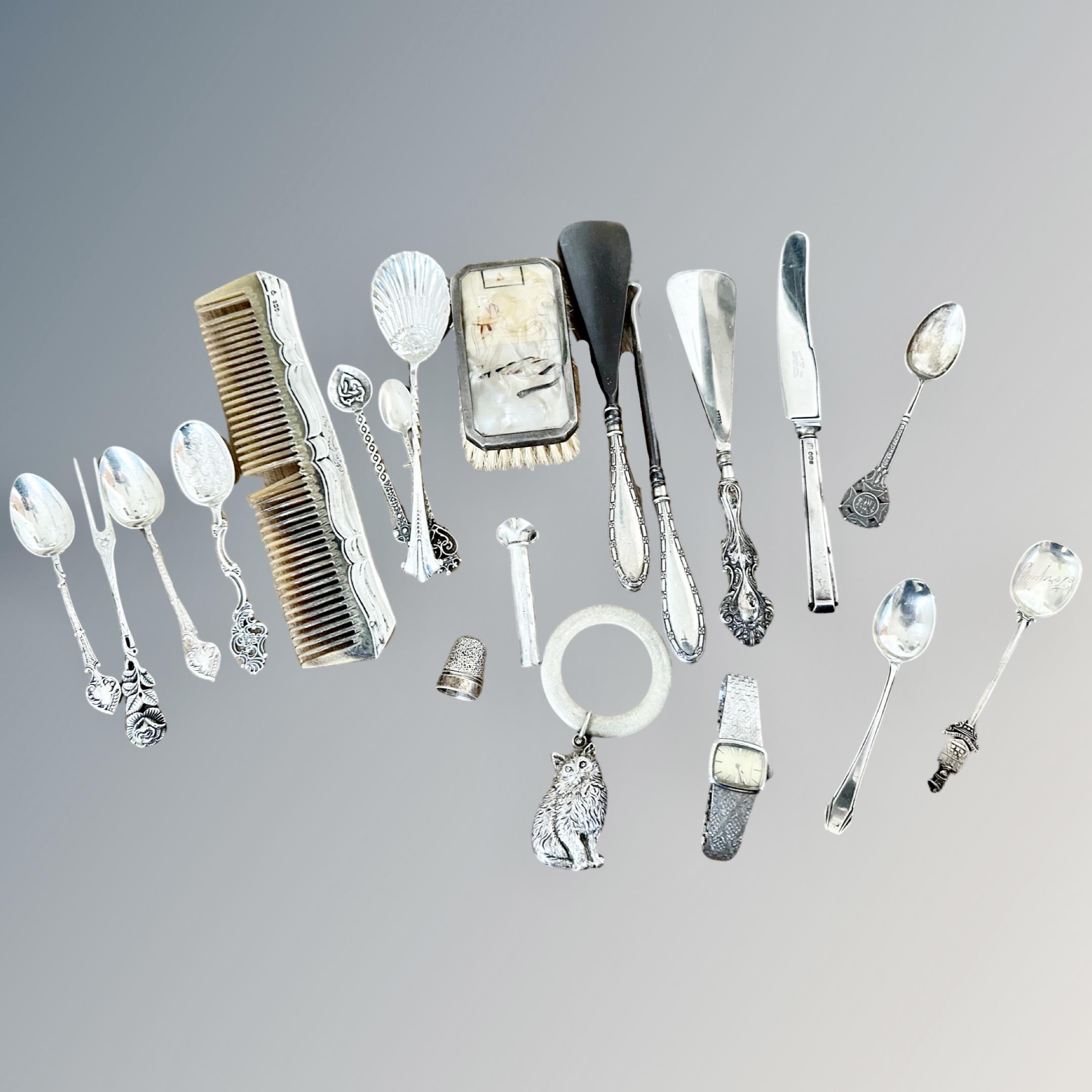 A group of silver cutlery and silver-mounted items, thimble, rattle,