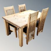 A pine farmhouse kitchen table together with four rail back chairs.
