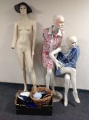 Three female shop mannequins (af) together with a box containing clothing and hats.