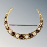 A 9ct gold garnet and seed pearl crescent brooch, diameter 28mm.