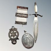 A silver bookmark in the form of a dagger and three medals/decorations.