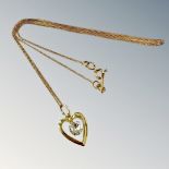 A 9ct gold cubiz zirconia heart pendant on trace link chain