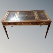 A reproduction mahogany bureau-plat with three fitted drawers and three inset leather panels,