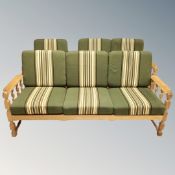 A Danish blonde oak framed three piece lounge suite with green striped cushions comprising of three