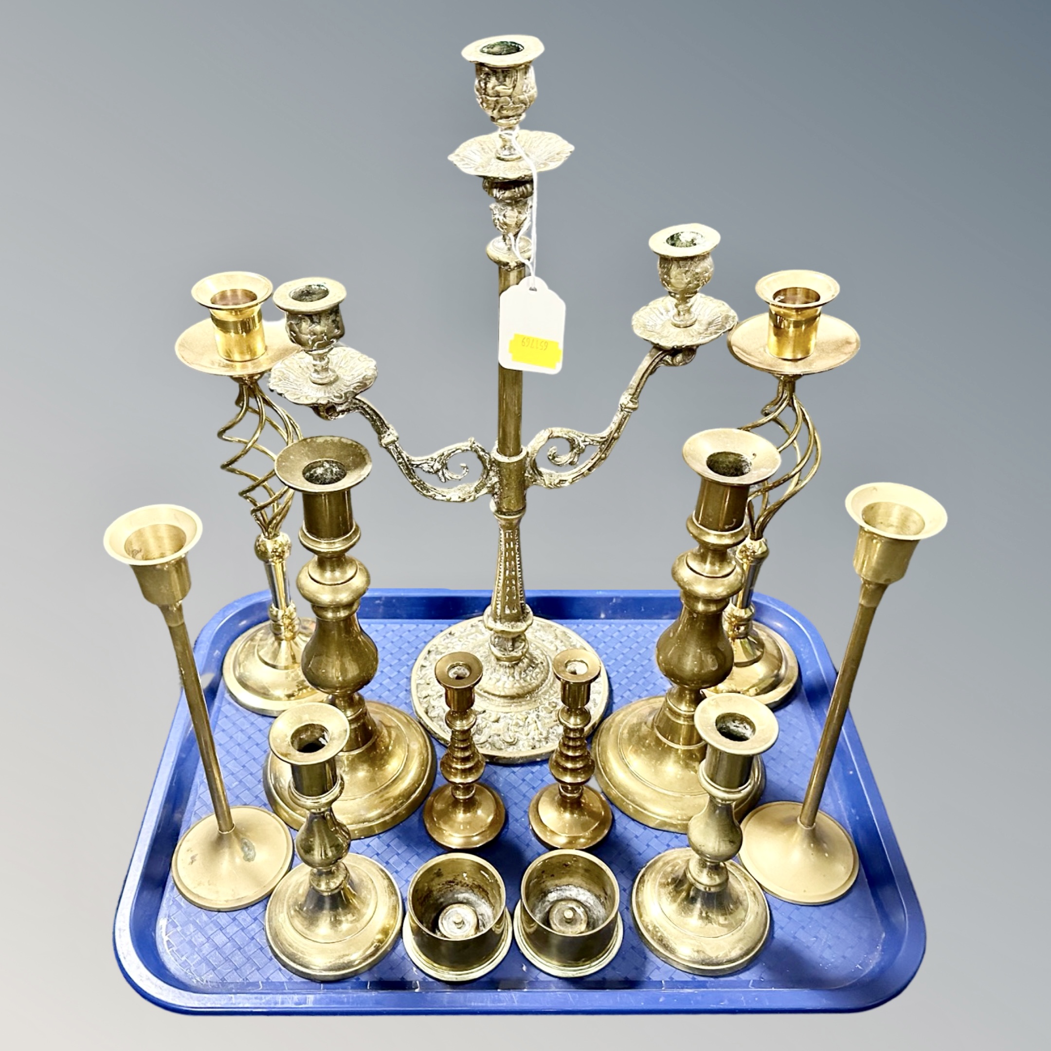 A tray containing six pairs of antique and later brass candlesticks together with a further