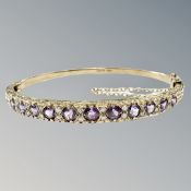 A 9ct gold amethyst and diamond bangle,