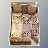 A box containing seven carved hardwood Asian book slides.