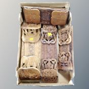A box containing seven carved hardwood Asian book slides.