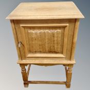 A Danish blonde oak low cabinet on raised legs,