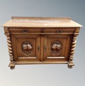 A 19th century oak double door sideboard with carved panel doors fitted drawers above with barley