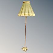 An antique brass and copper standard lamp with shade