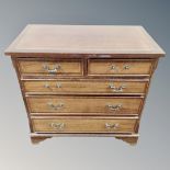 A Continental five drawer chest on bracket feet