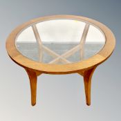 A 20th century teak circular lamp table with glass inset panel