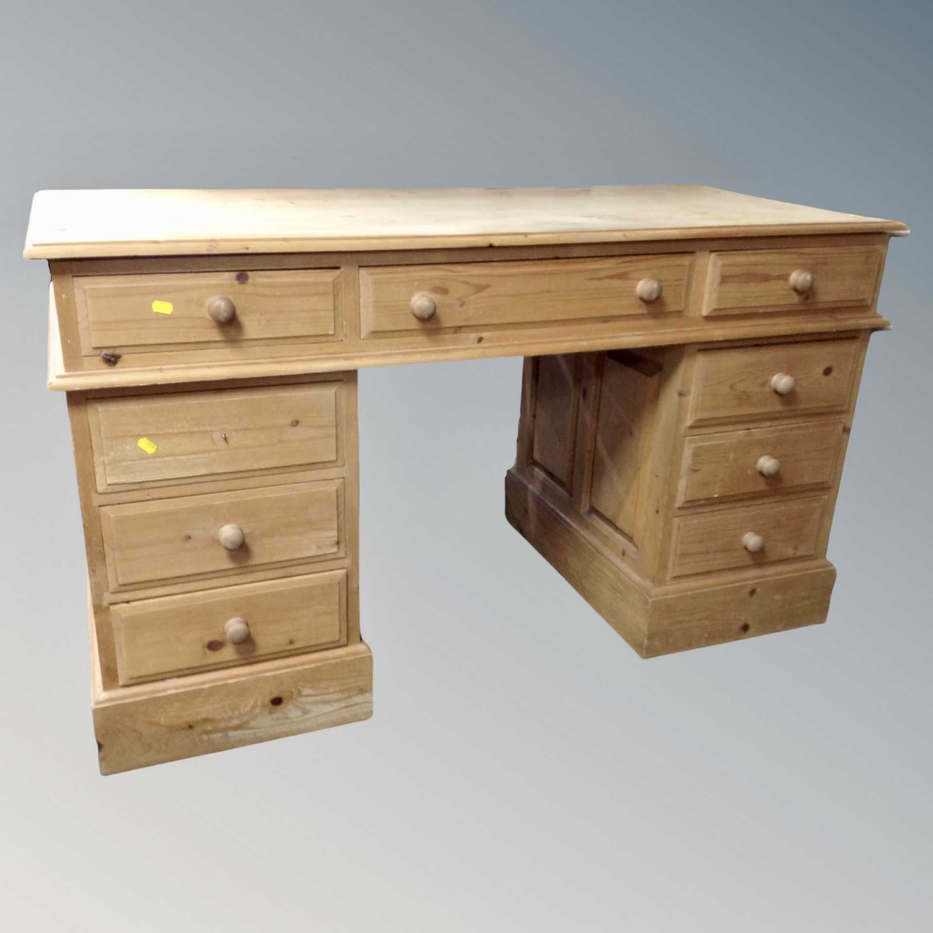 A pine nine drawer twin pedestal writing desk, height 80 cm, top 63 cm x 140 cm.